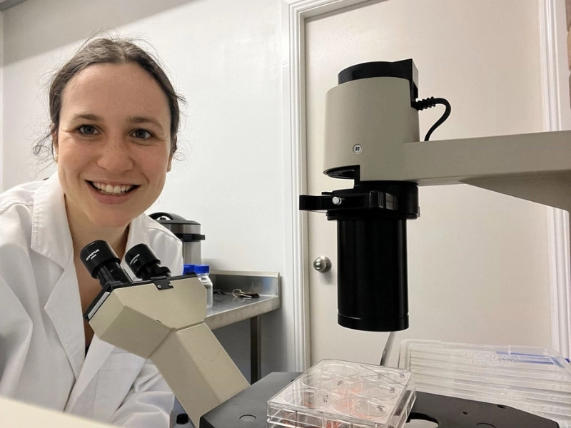 Scientist using a microscope in a laboratory, representing animal testing reform in New Zealand